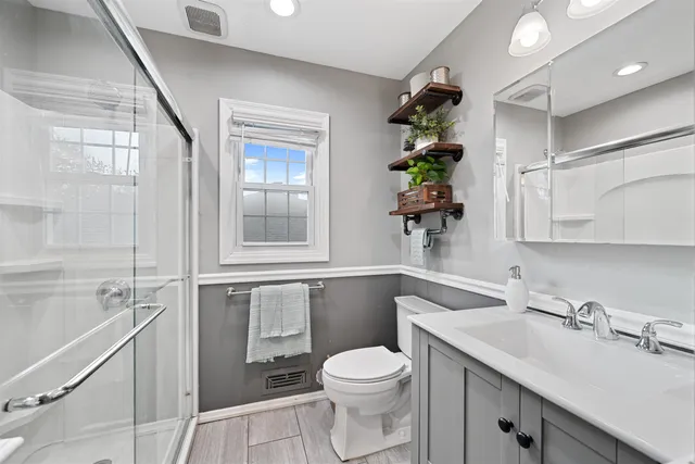 a bathroom with a sink a toilet and shower