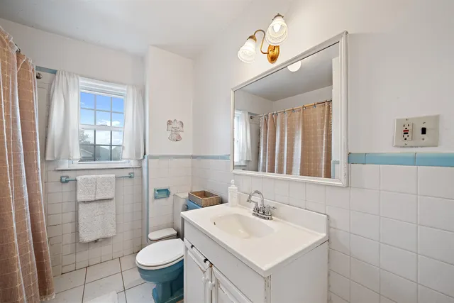 a bathroom with a sink a toilet and mirror