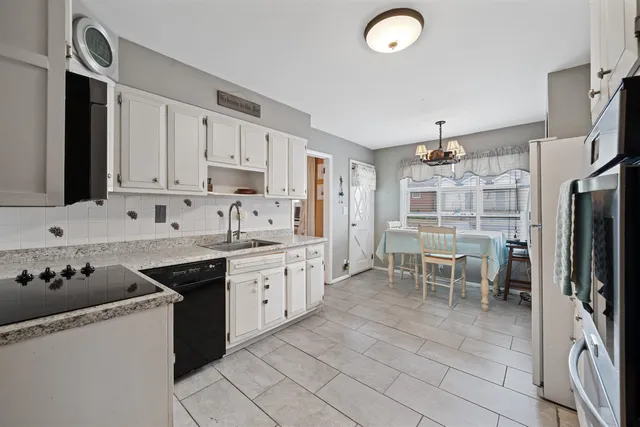 a kitchen with granite countertop cabinets a sink a window and stainless steel appliances