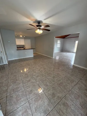 a view of a livingroom with a ceiling fan and window