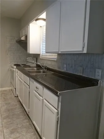 a kitchen with a sink and a mirror