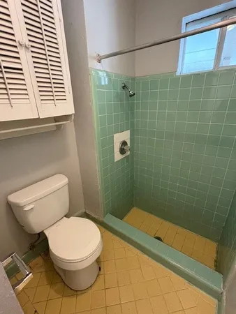 a bathroom with a toilet and a shower