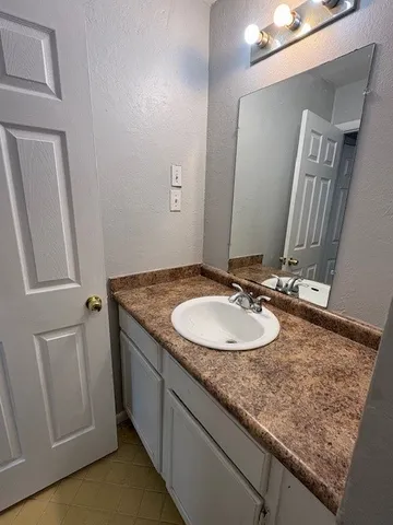 a bathroom with a granite countertop sink and a mirror