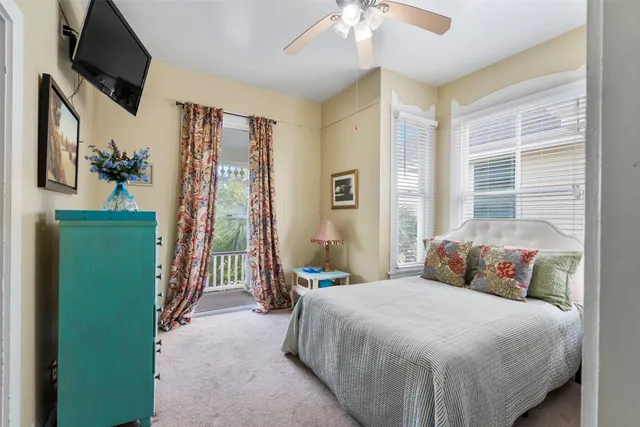 a bedroom with a large bed and a flat tv screen on dresser