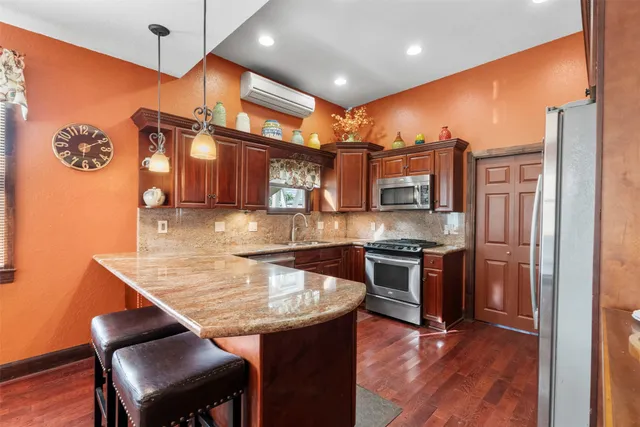 a kitchen with stainless steel appliances granite countertop a stove refrigerator and cabinets