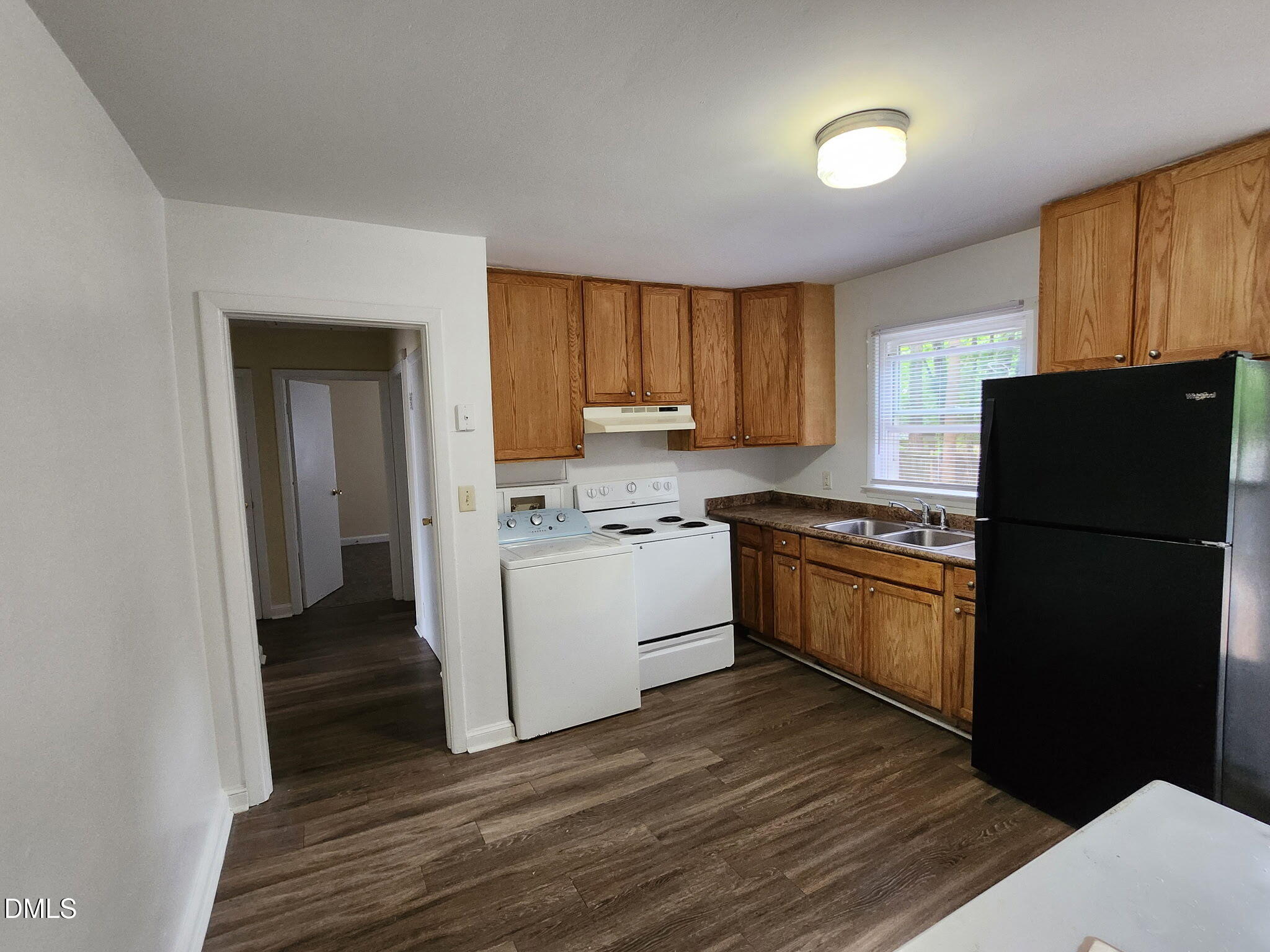 1302 Gorman Street Raleigh, NC 27606 - Photo 4 of 10 a kitchen with a refrigerator stove and wooden cabinets