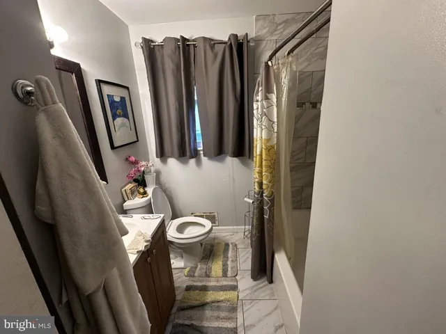 a bathroom with sink a mirror a toilet and a shower