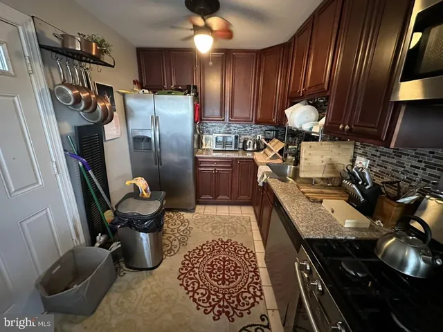 a kitchen with sink refrigerator and cabinets