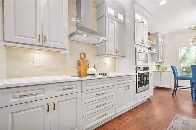a kitchen with stainless steel appliances kitchen island granite countertop a table chairs sink and cabinets