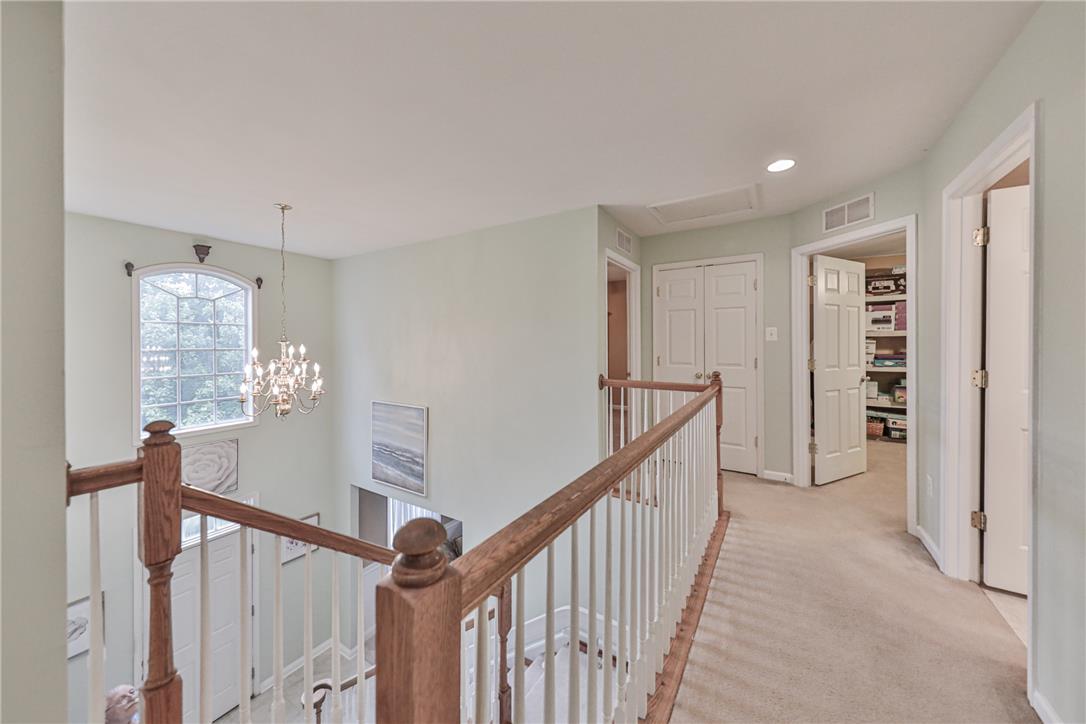138 Clover Hollow Road Easton, PA 18045 - Photo 60 of 95 A graceful staircase ascends to a well-lit hallway with plush carpeting, offering access to various rooms.