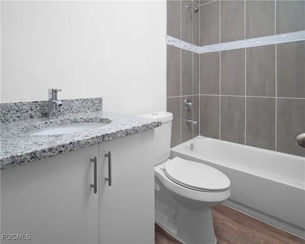 a bathroom with a granite countertop sink toilet and shower