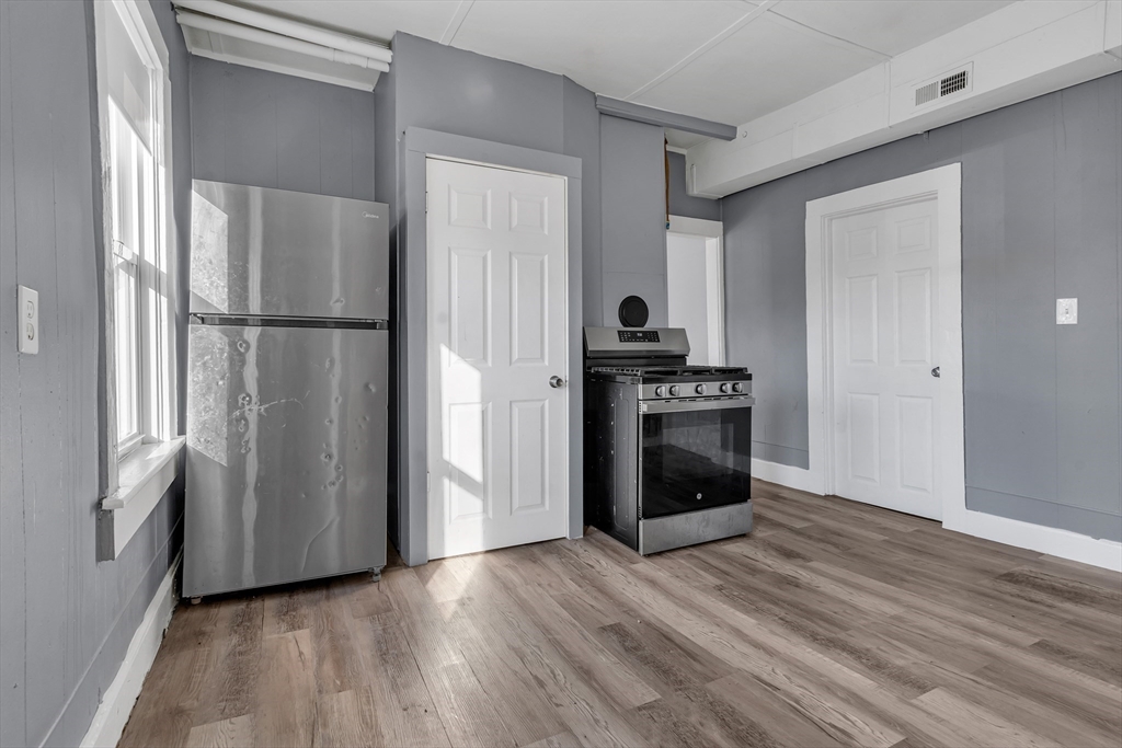 13 R Plain Street, Unit 2 Taunton, MA 02780 - Photo 4 of 21 a kitchen with a refrigerator and a stove top oven