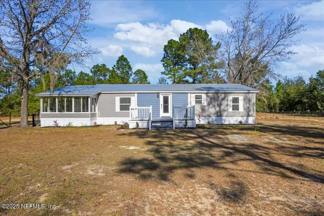 a view of a house with backyard and sitting area