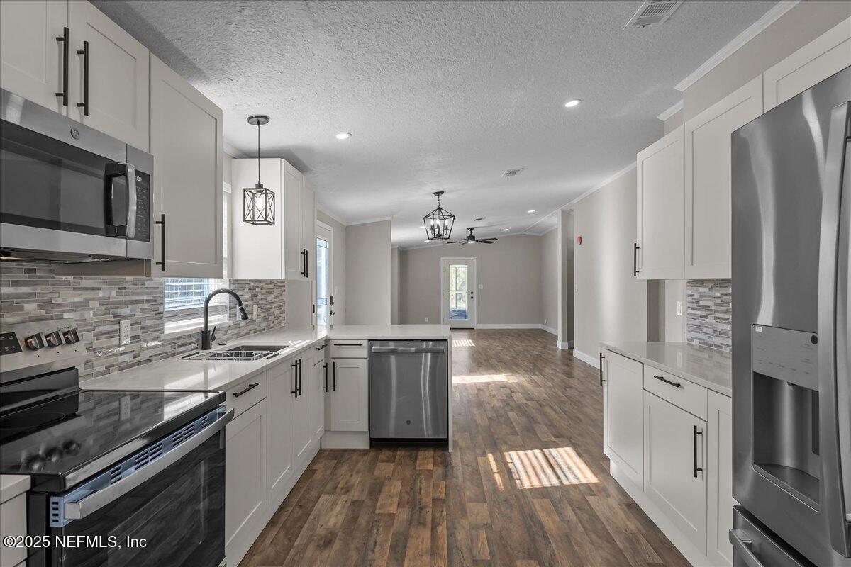 314 Union Avenue Interlachen, FL 32148 - Photo 20 of 30 a large kitchen with stainless steel appliances granite countertop a lot of counter space and wooden floors