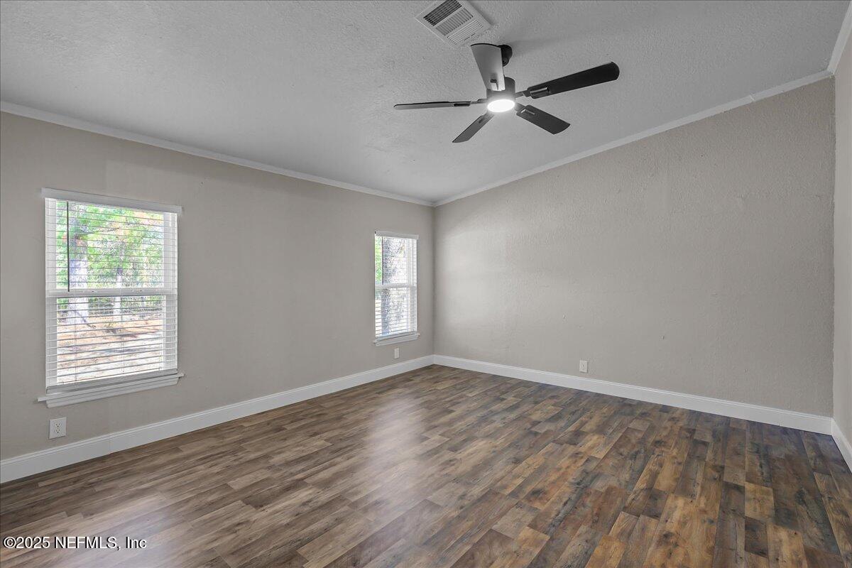 314 Union Avenue Interlachen, FL 32148 - Photo 23 of 30 an empty room with wooden floor fan and windows