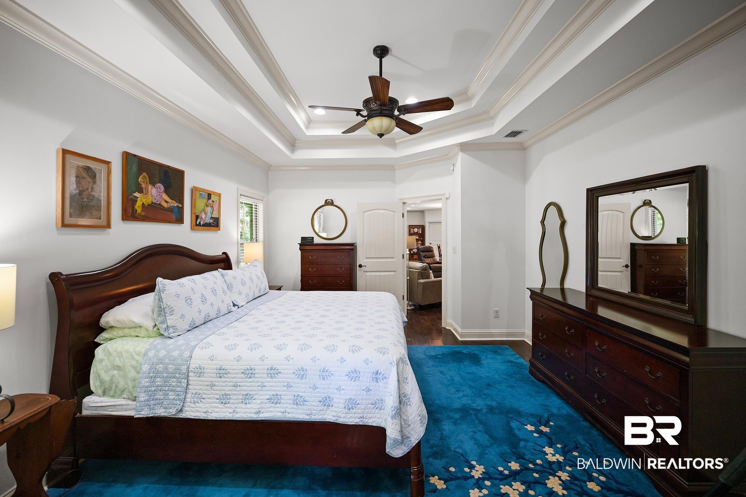 313 Pecan Ridge Boulevard Fairhope, AL 36532 - Photo 43 of 51 Recessed tray ceiling with crown molding, ceiling fan, wood-finish flooring, and white interior doors