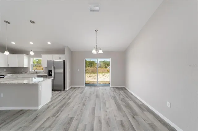 a view of kitchen with wooden floor electronic appliances and window