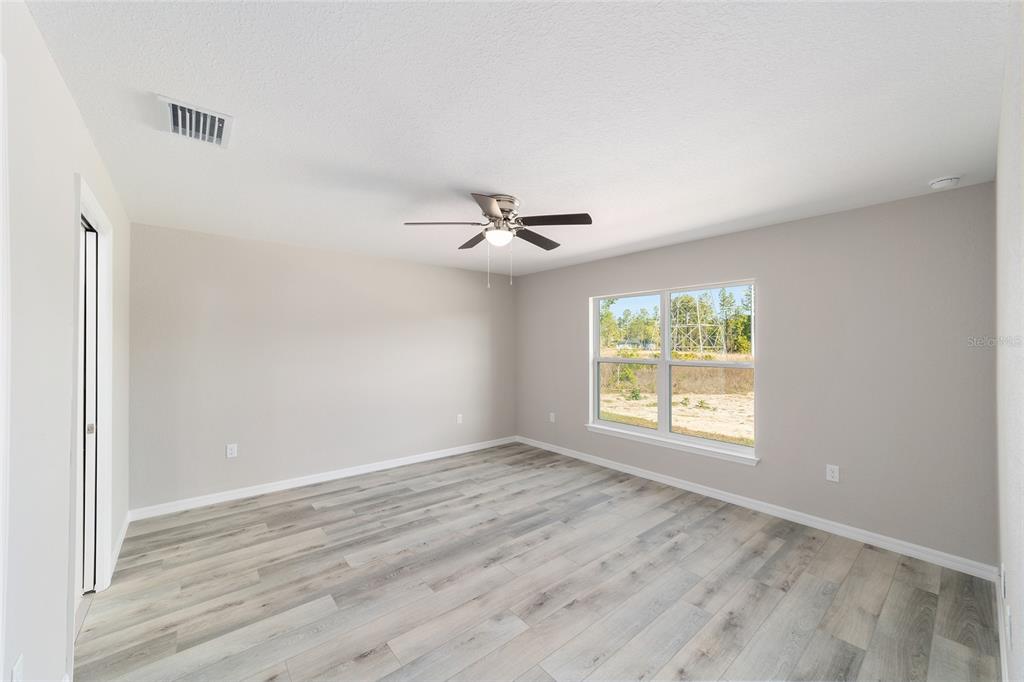 401 West Homeway Loop Citrus Springs, FL 34434 - Photo 16 of 23 a view of an empty room with wooden floor and a window