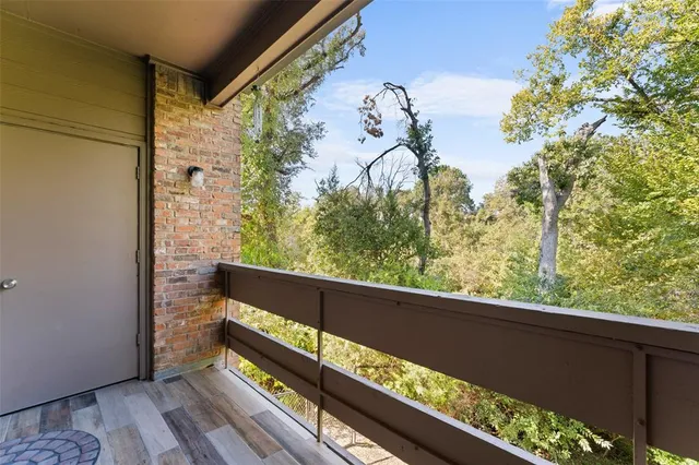 a view of a balcony with wooden floor and fence