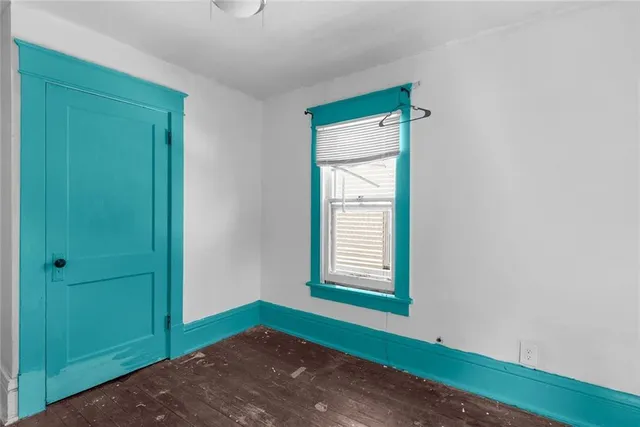 an empty room with window and closet area