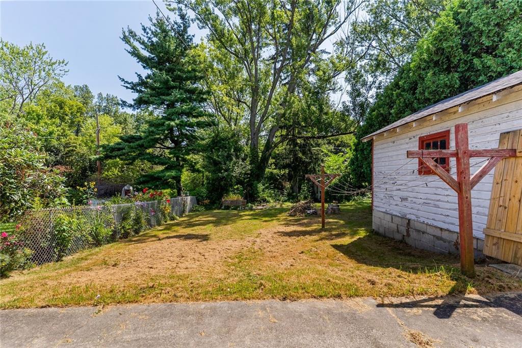 203 Baldwin Avenue Sharon, PA 16146 - Photo 5 of 27 a backyard of a house with large trees and wooden fence
