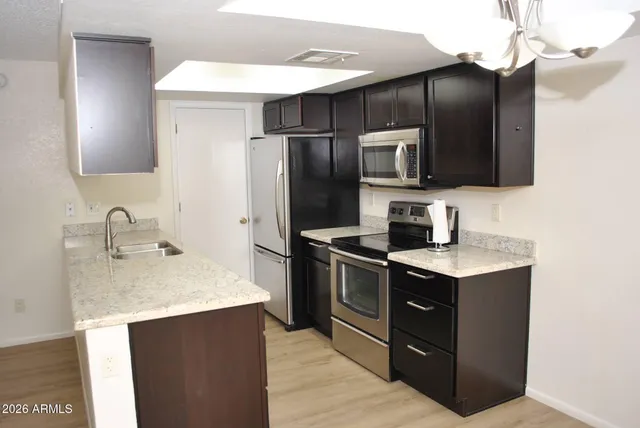 a kitchen with stainless steel appliances granite countertop a sink stove and refrigerator