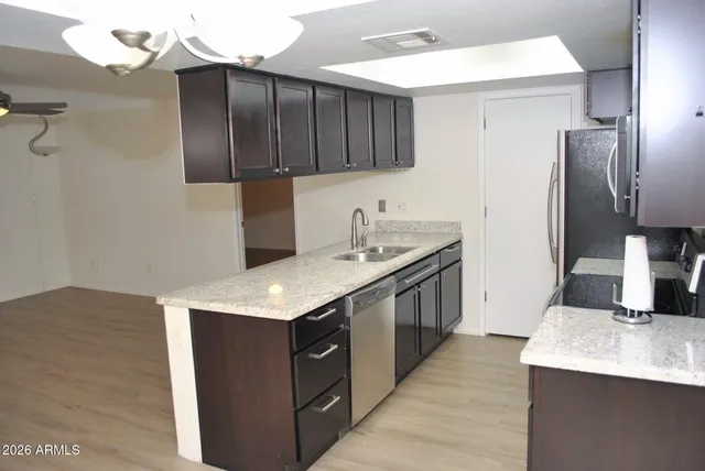 a kitchen with a sink refrigerator and cabinets