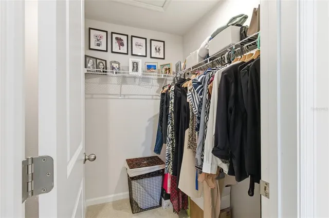 a view of walk in closet with clothes and shoes