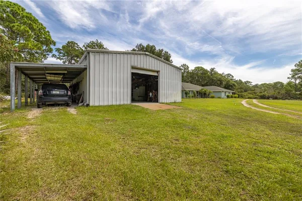 a view of a yard with swimming pool and trees