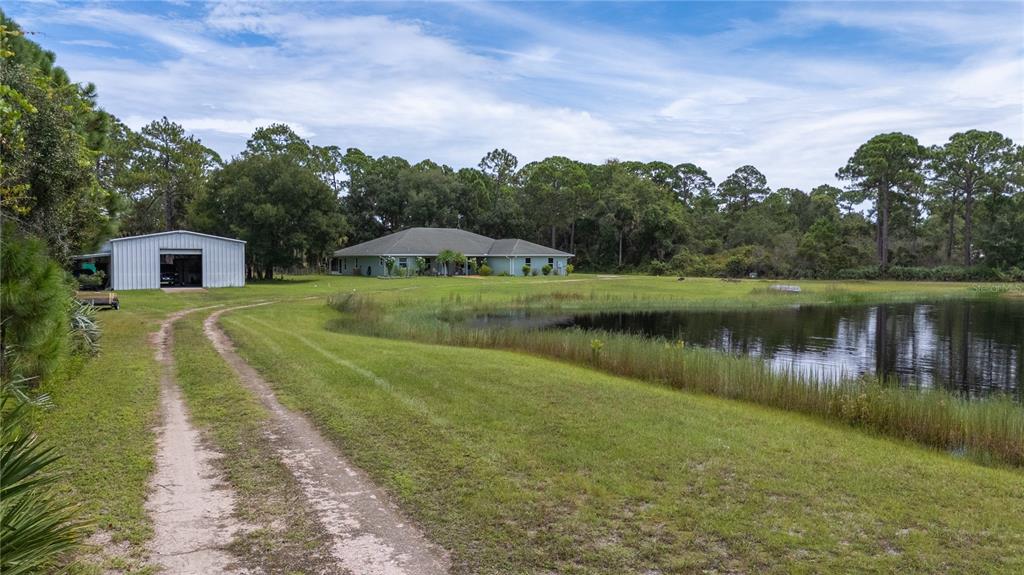4245 Clinton Cemetery Road Edgewater, FL 32141 - Photo 40 of 60 a view of a lake with a house in the background