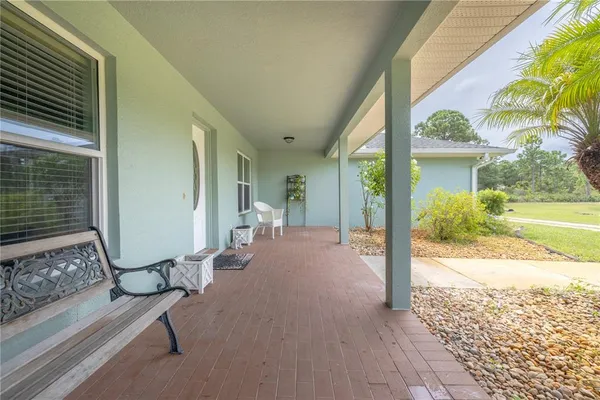 a view of a porch with wooden floor and a yard