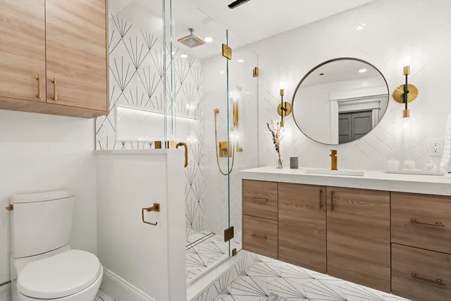 a bathroom with a sink a toilet and shower