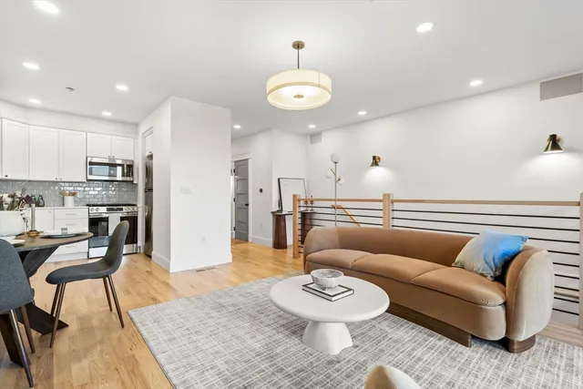 a living room with furniture kitchen view and a table