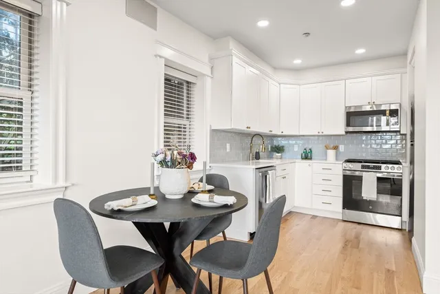 a kitchen with a dining table chairs and microwave