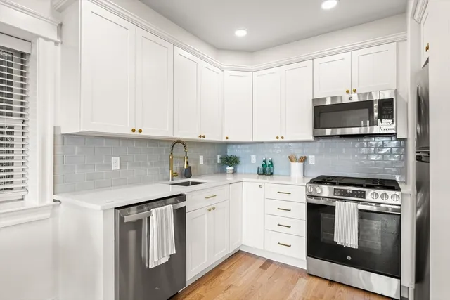 a kitchen with stainless steel appliances granite countertop a stove a sink and a microwave