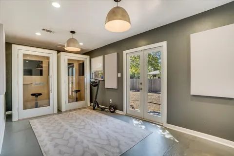 a view of a livingroom with a chandelier fan and windows