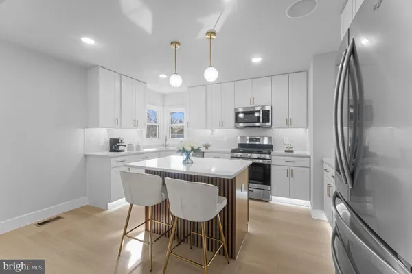 a kitchen with kitchen island a sink stove and refrigerator