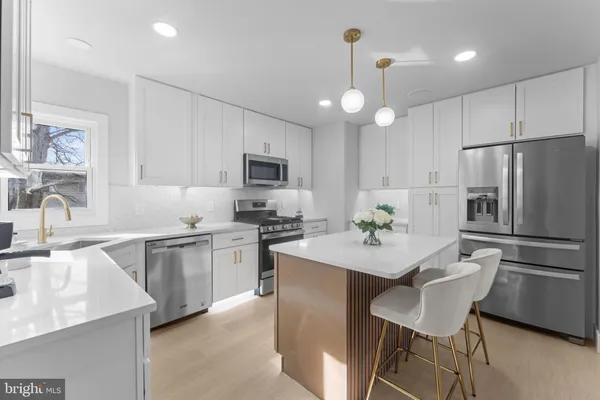 a kitchen with a center island appliances and cabinets