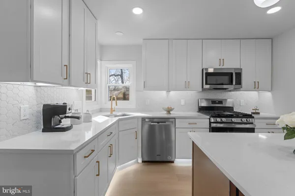 a kitchen with cabinets appliances a sink and a counter top space