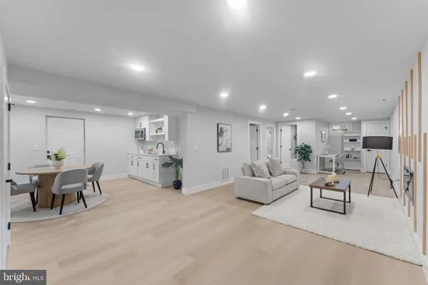 a living room with furniture and a dining table with kitchen view