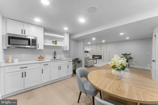 a kitchen with stainless steel appliances kitchen island granite countertop a sink dishwasher a microwave oven with a dining table and chairs