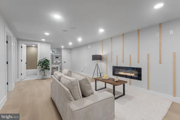 a living room with furniture a wooden floor and a potted plant