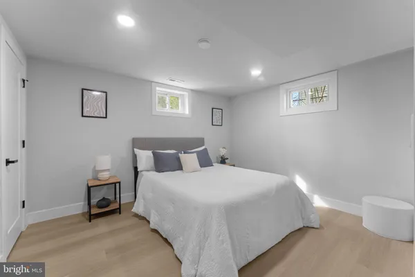 a spacious bedroom with a bed and a lamp