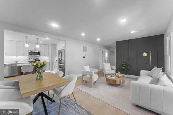 a living room with furniture kitchen view and a wooden floor