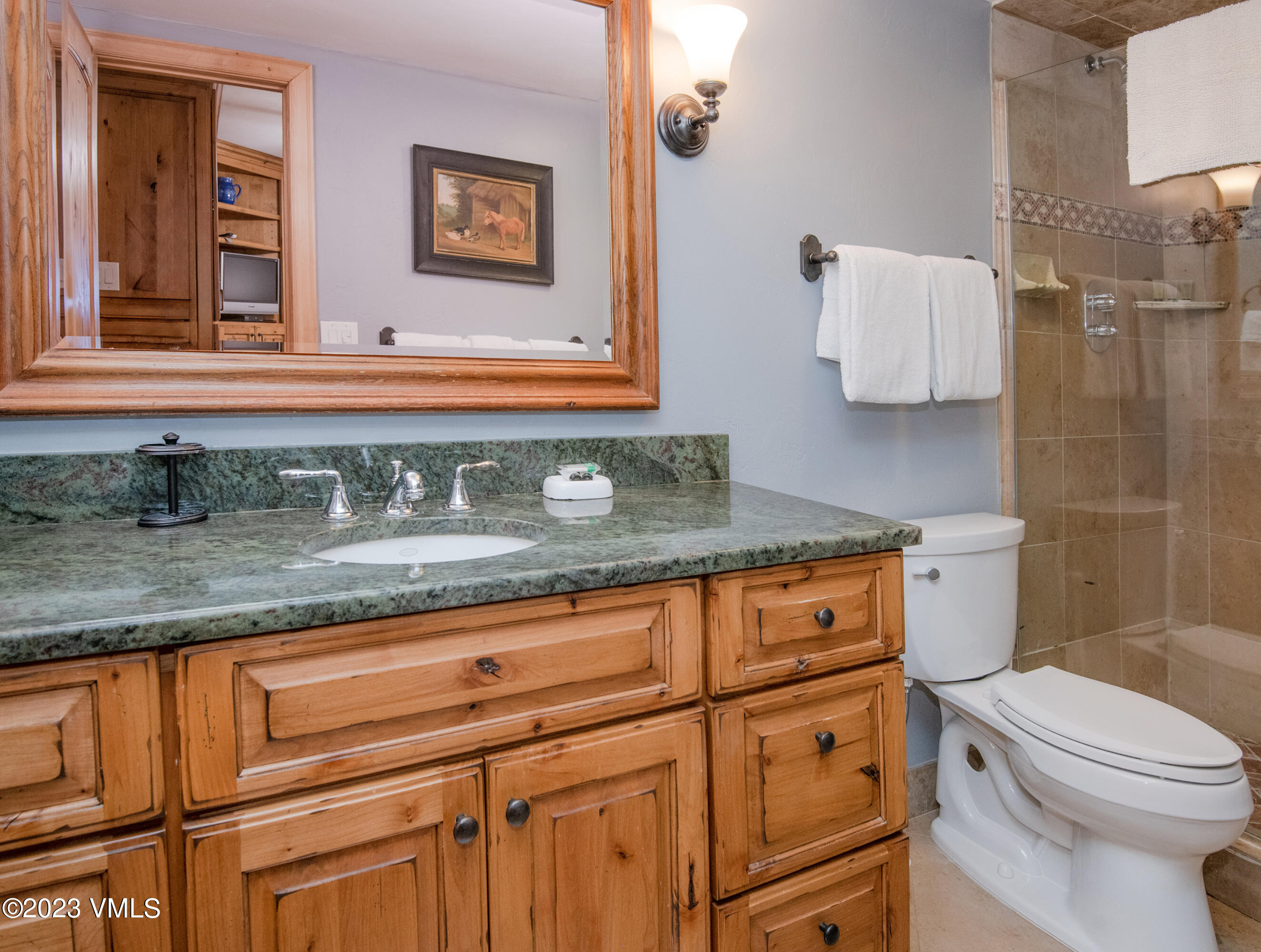 442 South Frontage Road East, Unit 103B Vail, CO 81657 - Photo 16 of 32 a bathroom with a granite countertop sink a toilet and mirror
