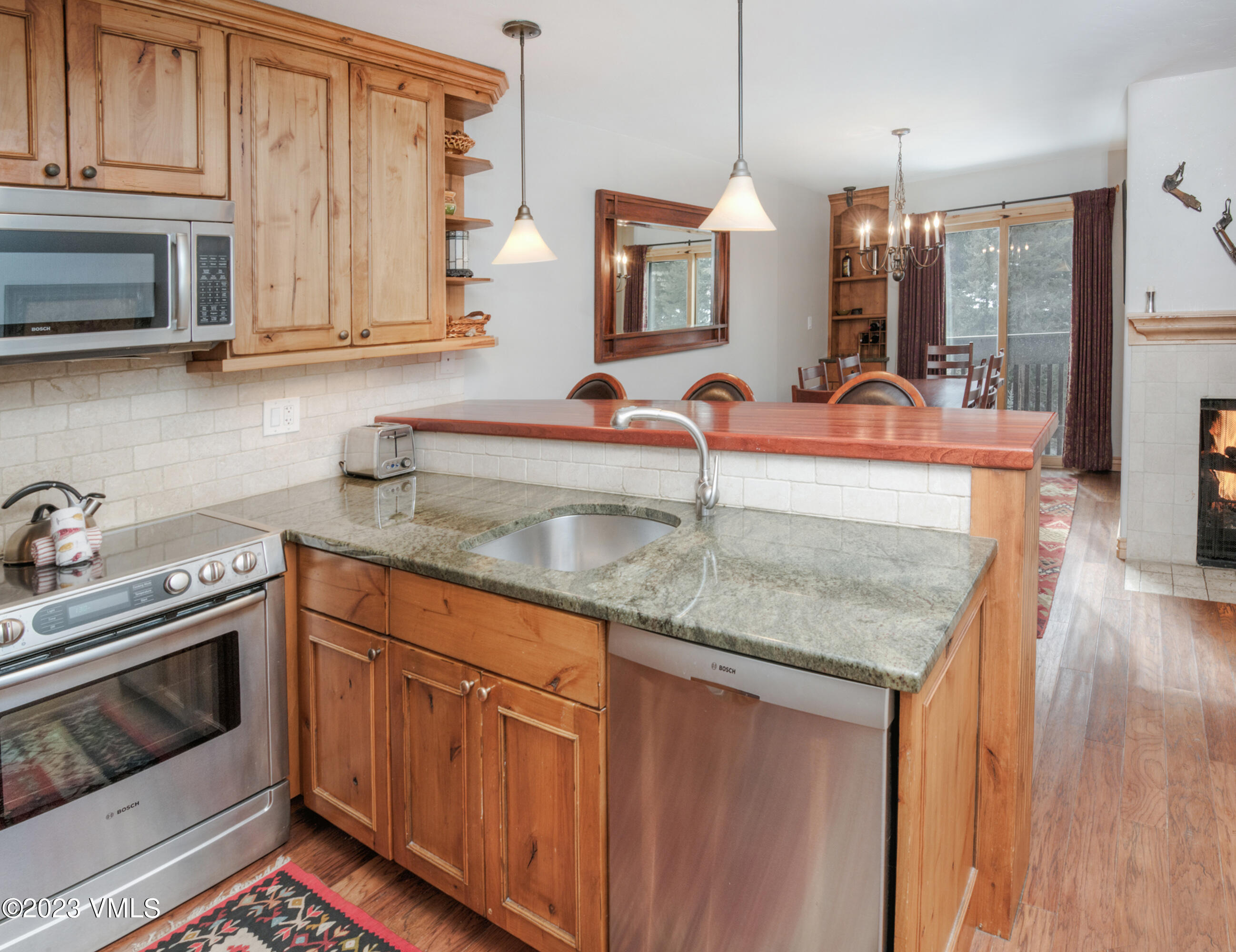 442 South Frontage Road East, Unit 103B Vail, CO 81657 - Photo 2 of 32 a kitchen with stainless steel appliances granite countertop a sink stove and microwave