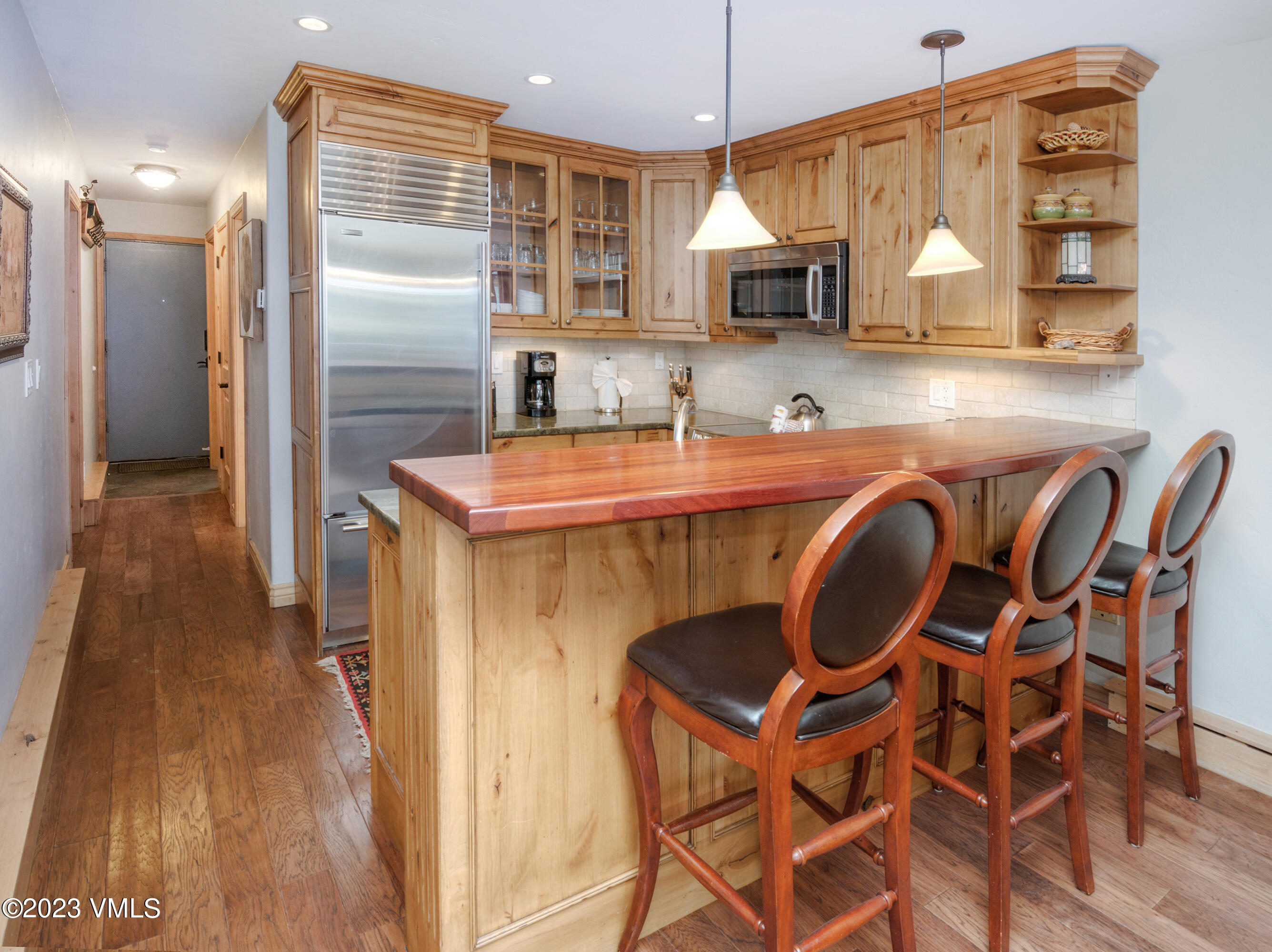 442 South Frontage Road East, Unit 103B Vail, CO 81657 - Photo 3 of 32 a kitchen with a table chairs refrigerator and microwave