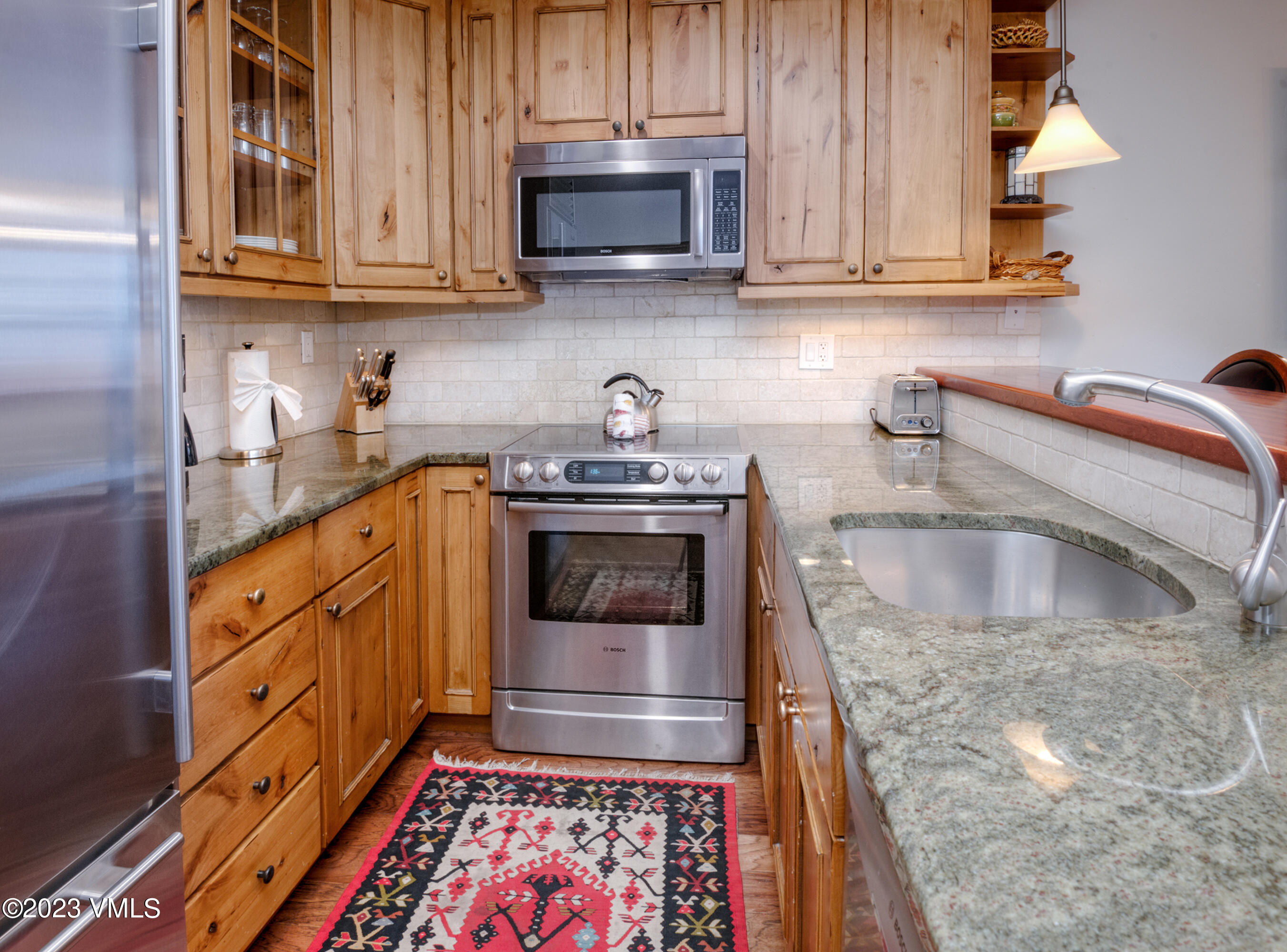 442 South Frontage Road East, Unit 103B Vail, CO 81657 - Photo 4 of 32 a kitchen with granite countertop a sink a stove and cabinets
