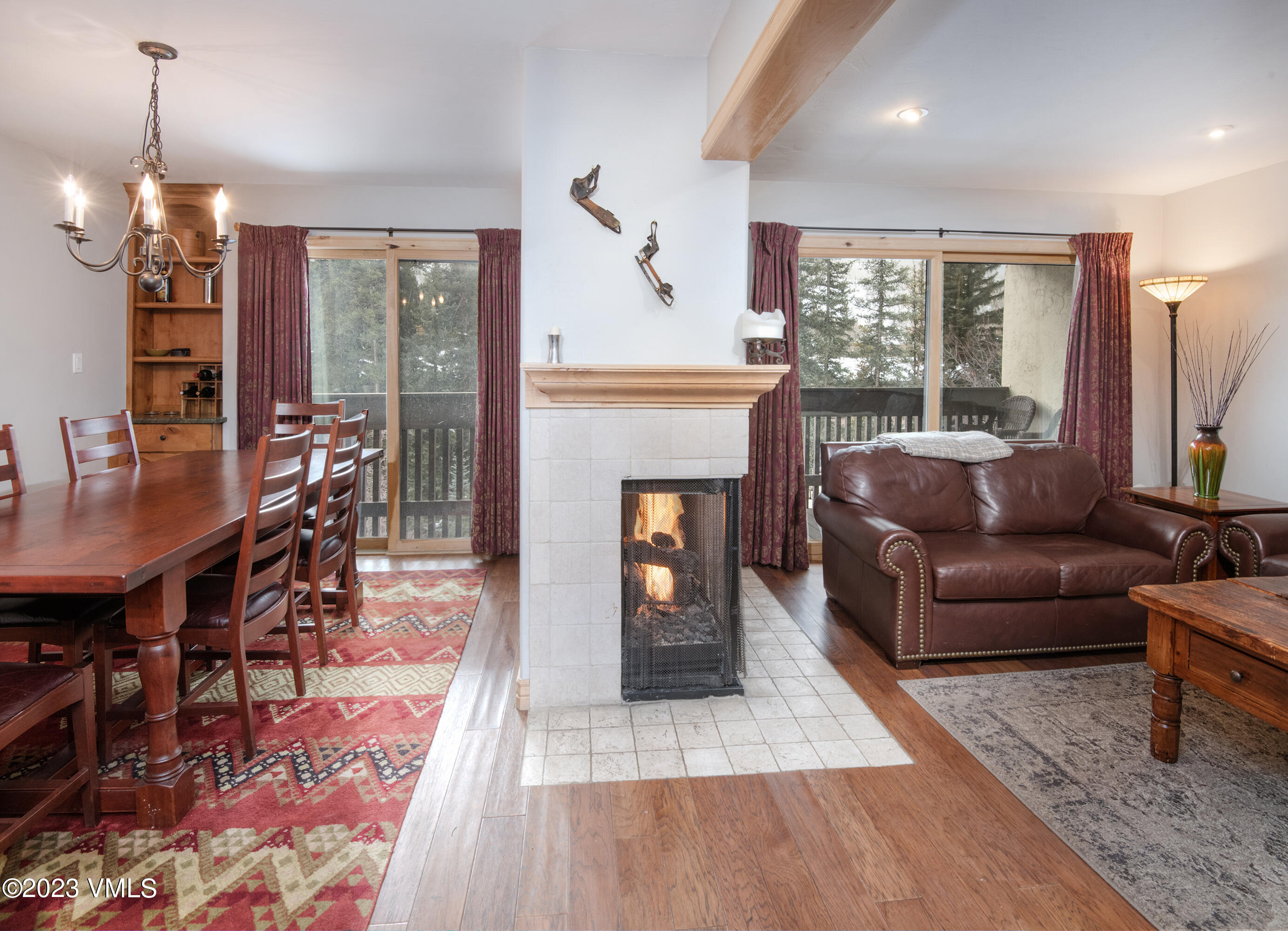 442 South Frontage Road East, Unit 103B Vail, CO 81657 - Photo 7 of 32 a living room with furniture a fireplace and a dining table with wooden floor