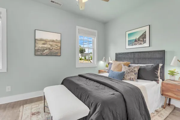 a bedroom with a bed and a lamp on dresser